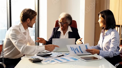 Business professionals engaged in a meeting with laptops and documents on a white table
