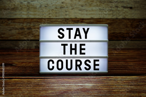 Bilde på lerret Lightbox with text Stay The Course on wooden background