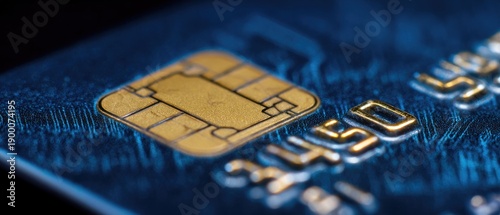 A close-up view of a blue credit card with a gold chip and embossed numbers