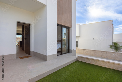 Foto Modern home entrance with artificial grass and sliding bedroom window
