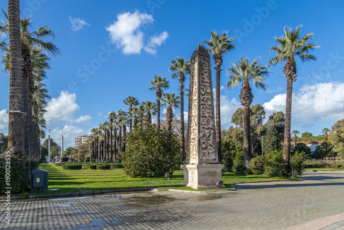 Fotografía Scenic palm trees lining a wide path with an egyptian style obelisk at Kulturpark in Izmir, Turkey