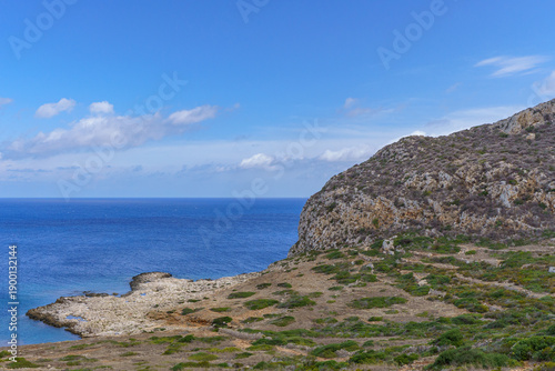 Wallpaper Mural A picturesque view of Puntazza A Carcara, a beautiful, secluded cove on Levanzo Island, featuring vibrant turquoise and deep blue Mediterranean water gently meeting a rocky beach, ideal for themes of  Torontodigital.ca