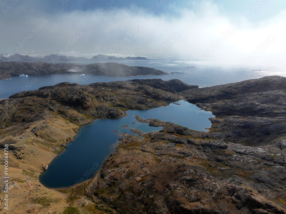Obraz premium View of the waterfront infrastructure in Tasiilaq, Greenland. The clip shows the port area with shipping containers, fishing boats, and local housing, highlighting life in a remote Arctic community 