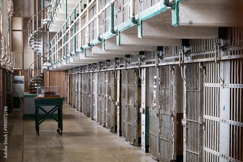 Empty prison cell block corridor with metal doors