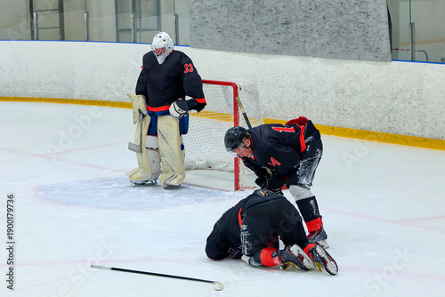 hockey player is injured and lying on the ice