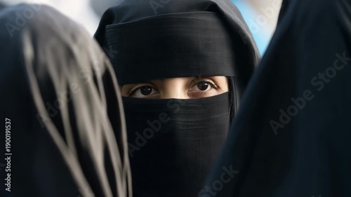 Afghan women wearing black niqab, only eyes visible, central woman perfectly centered and facing camera, intense direct gaze, surrounding women tightly packed around her  4K