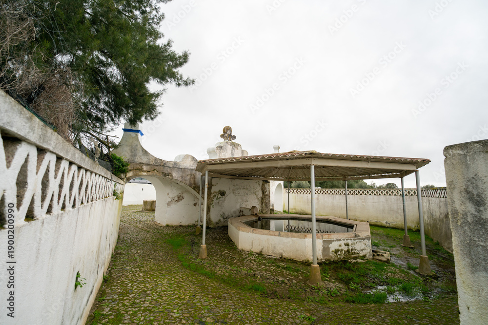 Fototapeta premium Stone fountain in Arraiolos, Portugal, showcasing traditional architecture and historic charm in a picturesque village setting.
