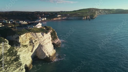 Drone footage of a chalky cliff coastline at sunrise