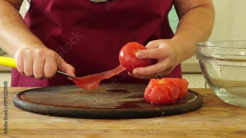 Woman cooking sauce with fresh tomato at the kitchen