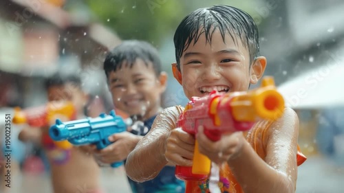 Joyful Asian People Celebrating Songkran Festival with Colorful Water Guns, Splashes, and Laughter, Marking Thailand’s Traditional New Year and a Cherished Buddhist Celebration.