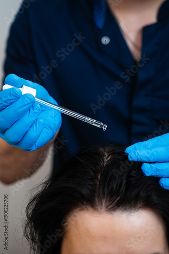 Bild auf Leinwand Trichologist applies scalp serum to stimulate hair growth after treatment