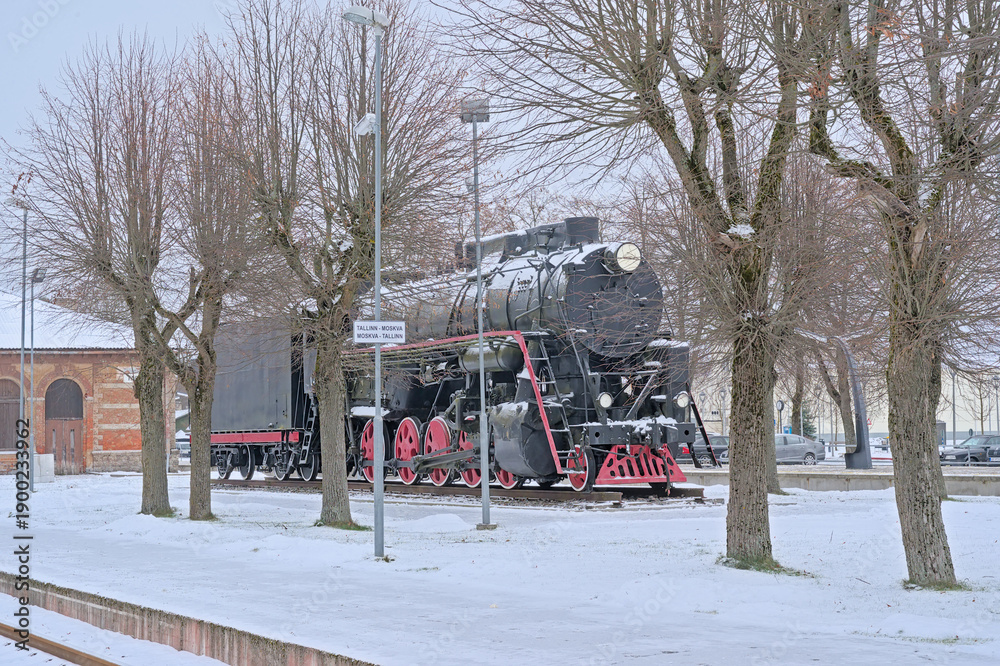 Naklejka premium Old steam locomotive in the snow on the tracks of tapa ralway station, Estonia 