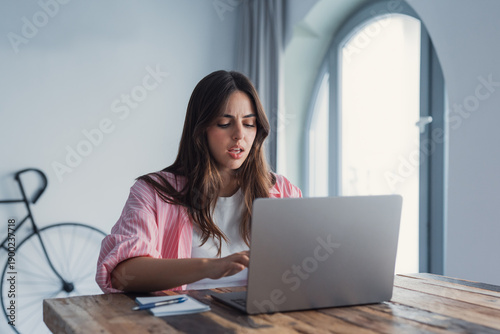 Fotografia Frustrated stressed woman sit at desk near laptop hold head with hands feels des