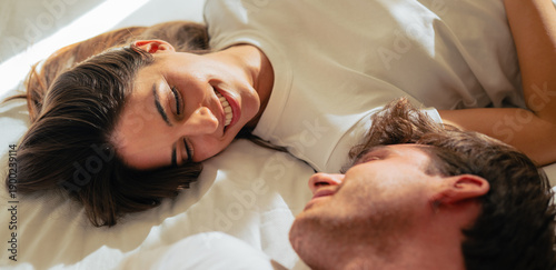 Foto Two young lovers rest in bed, looking into each other’s eyes and expressing tend