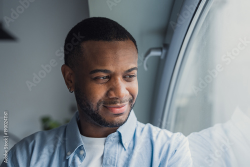 Quadro su tela A positive and reflective Black businessman looks out the window while imagining