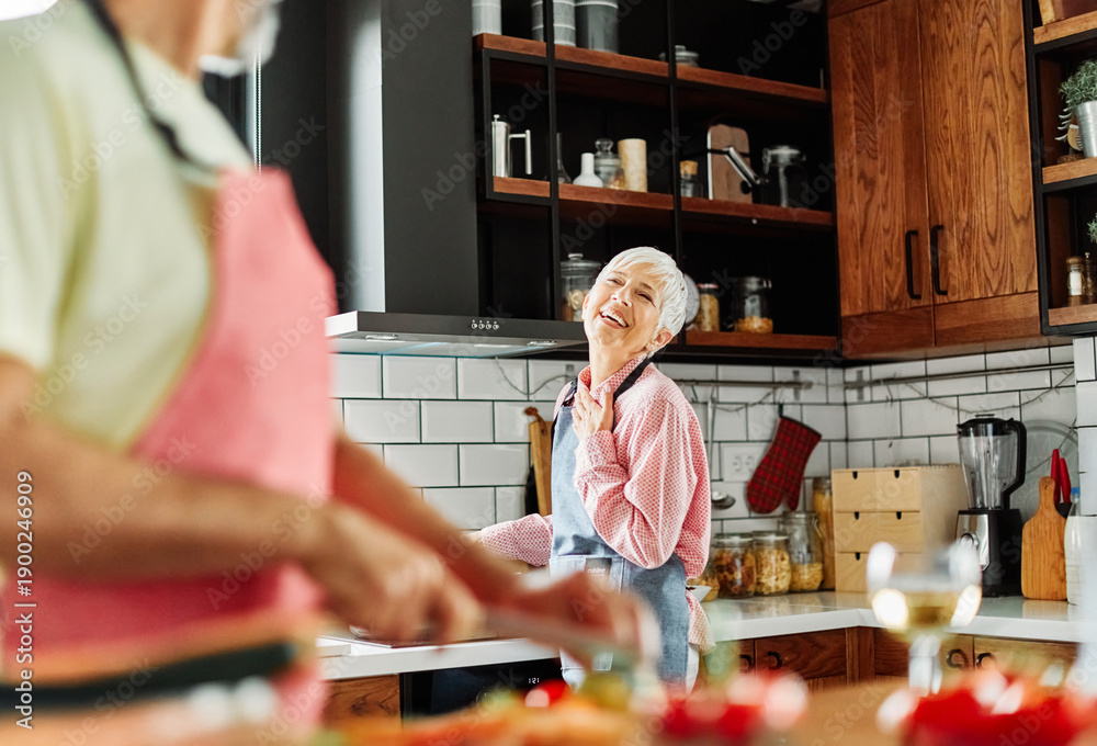 Obraz premium Portrait of happy senior mid aged mature couple prepering meal with fresh vegatebles in kitchen at hpme