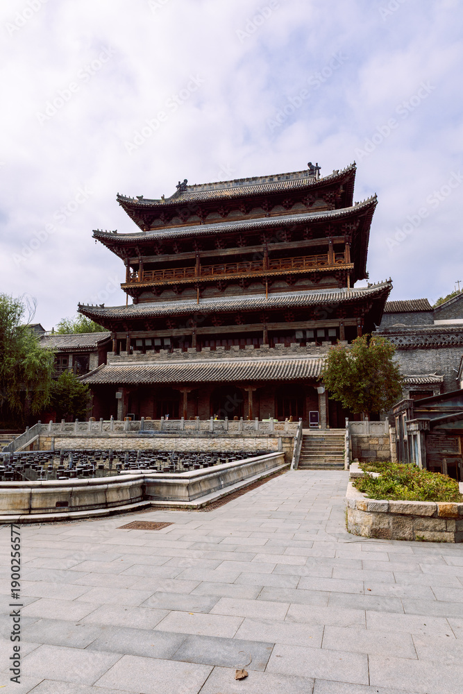 Fototapeta premium Chinese pagoda style building with tiled roofs stone base and symmetrical layout in Gubei Town China. Vertical photo