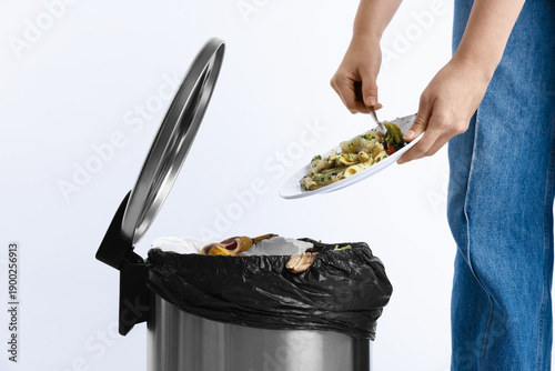 Принти на полотні Woman throwing food waste into garbage can on white background, closeup