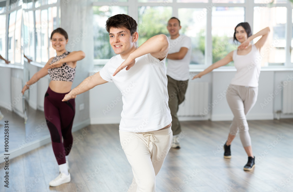 Fototapeta premium Smiling people practicing vigorous lindy hop movements in dance class