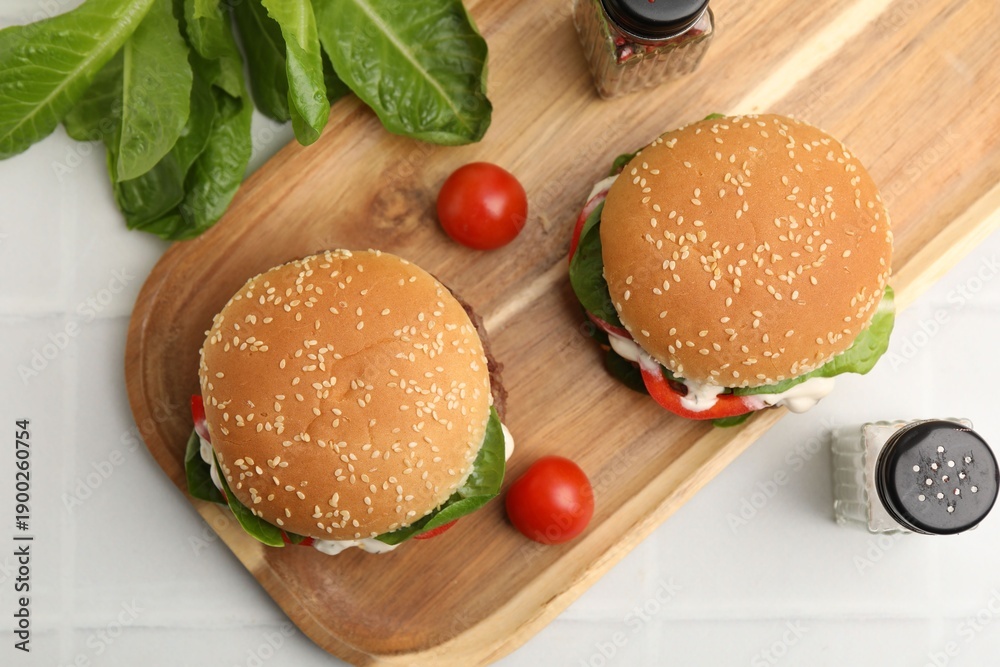 Naklejka premium Delicious burgers with meat patties on white table, flat lay