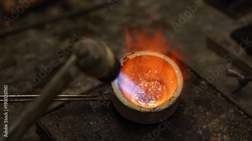 Manual gold melting using a torch before casting jewelry 4k video. Gold being melted by torch during jewelry production.