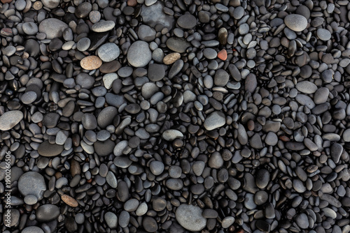 Top down macro texture of smooth basalt pebbles on Reynisfjara Black Sand Beach, Iceland