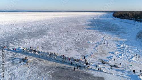 Frozen Baltic Sea At Beach With Ice Covered Old Wooden Pier And People Walking On The Ice Enjoying A Sunny Winter Day Scenic Latvia 4K Footage For Travel Nature Seasonal Projects