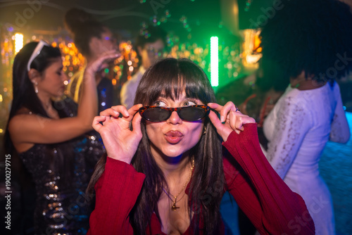 Tableau sur toile Woman making kiss face at vibrant nightclub party