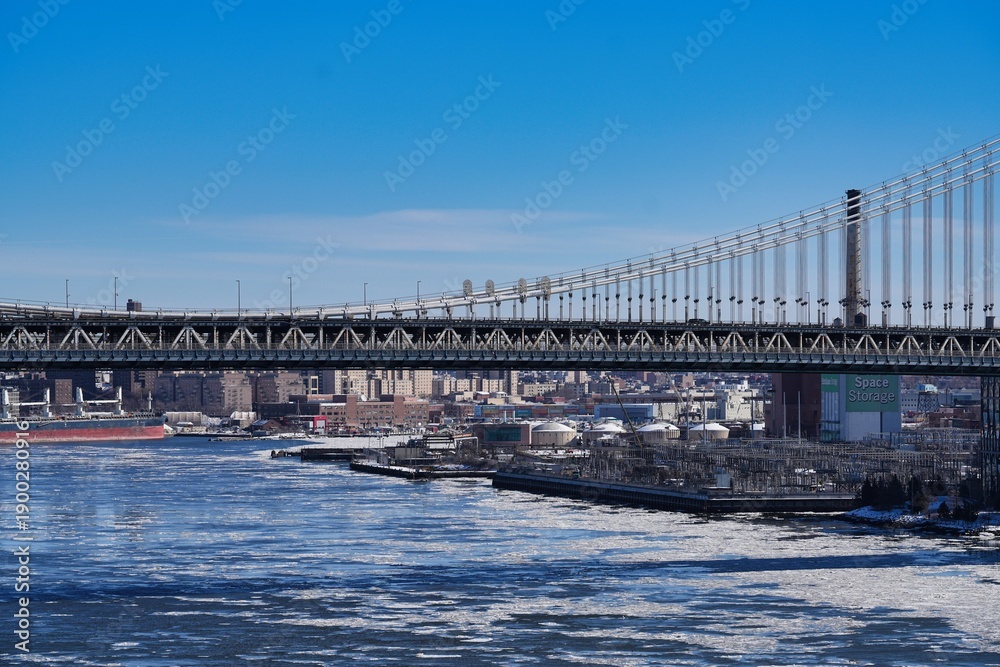 Naklejka premium The Manhattan Bridge and ice floes on the East River in New York City.
