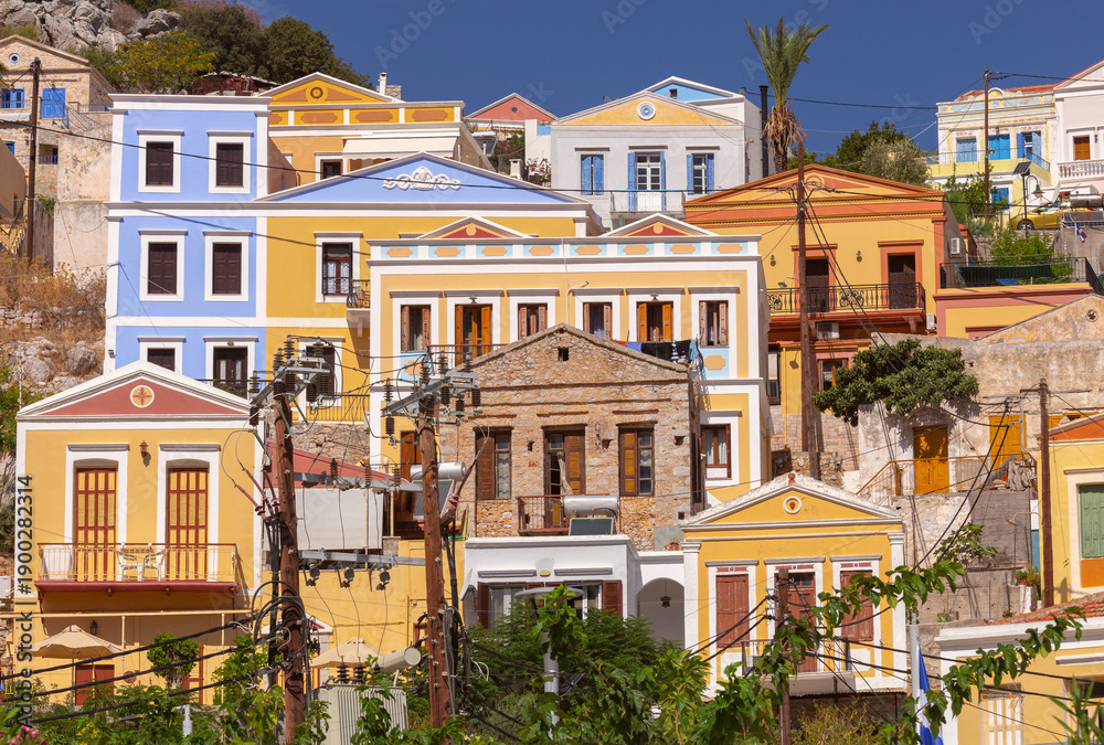 Fototapeta premium Colorful houses on hillside in Symi island Greece