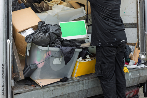 Φωτογραφία Worker unloading mixed waste and household items from van or truck