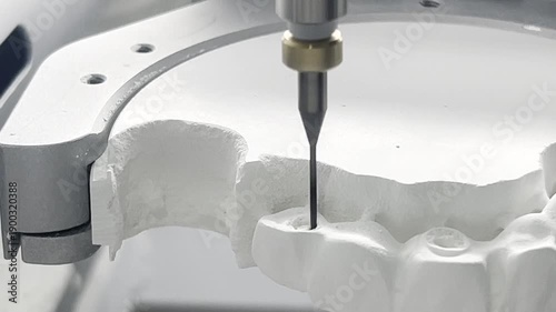 Close up. Professional CNC dental milling machine carving out shape of artificial teeth in the dental lab. One of the steps in making of artificial teeth by dental technician in the clinic.