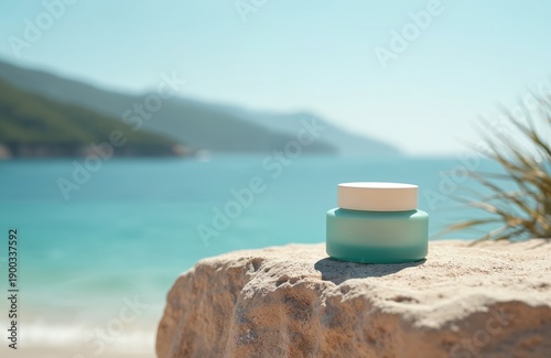Cosmetic cream jar rests on a rough stone on a beach. Blue ocean and green mountains form the backdrop for this natural beauty product display. Perfect for skincare branding and summer ads.
