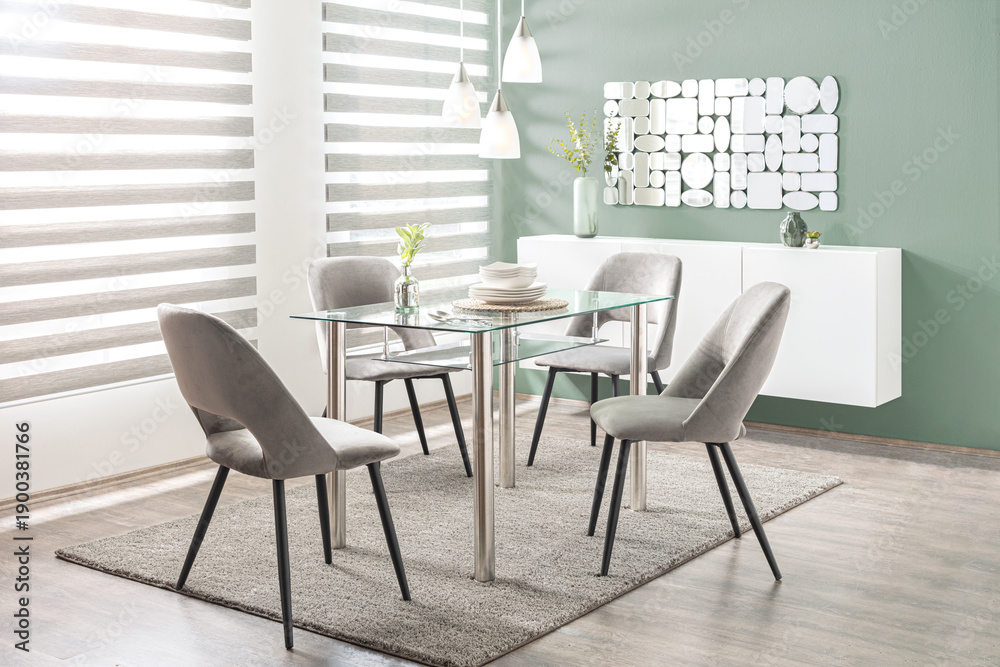 Fototapeta premium A tastefully appointed modern dining room with a glass table and chairs, situated in front of a large window with the grey blinds pulled up