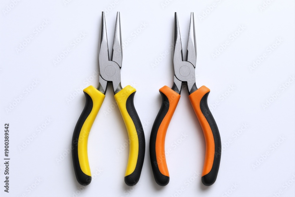 Obraz premium Two needle-nose pliers with yellow and orange grips, arranged symmetrically on a white surface