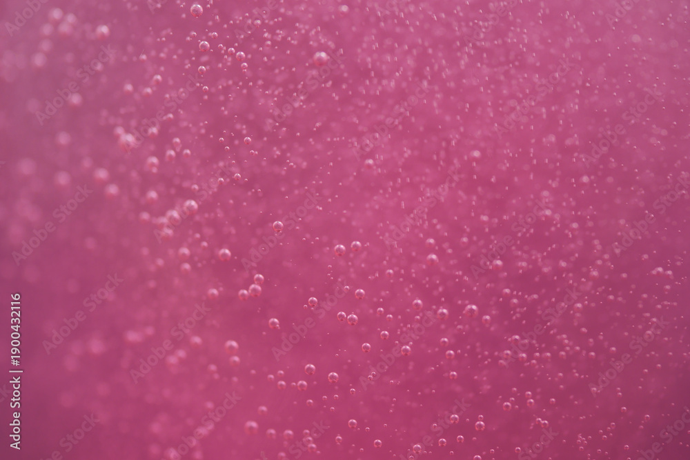 Obraz premium Bubbles rise in bright pink liquid during a close view