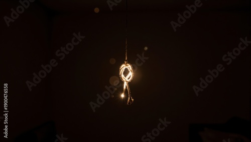 Wallpaper Mural A lit hemp rope tied in a knot hangs from a thin wire in a dark room light Torontodigital.ca