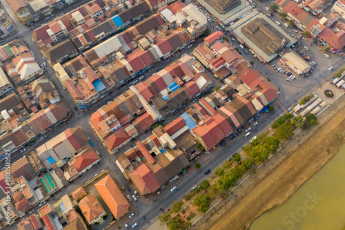 Obraz na płótnie High-angle aerial image of Battambang, Cambodia, showing a grid of colorful rooftops, intersecting streets, and riverside greenery
