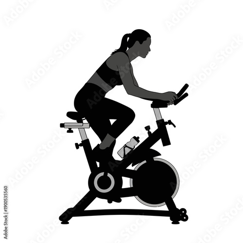 Silhouette of a woman cycling on a stationary bike for a workout