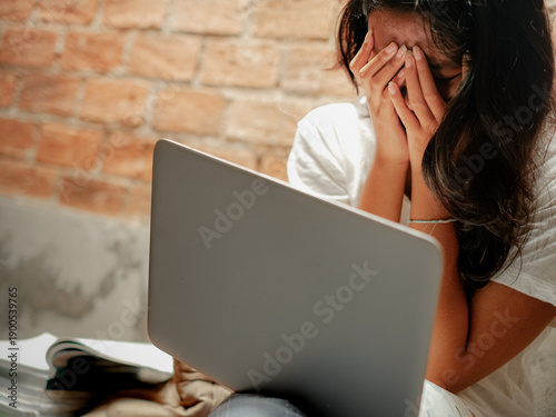 Cuadro en lienzo Asian young woman covering her face with her hands, crying, emotional, depressed, stressul, upset, embarrassed and ashamed due to bullying, gossip and harassment on social media