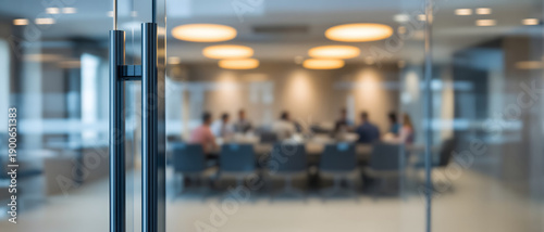 Modern office conference room background with blurred business people working together at table behind glass partition wall, close up focus on metallic door handle entering boardroom.