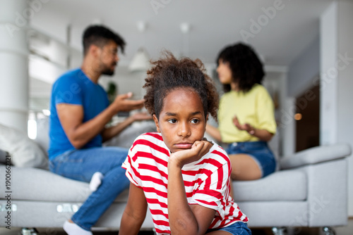 Canvas Print Pensive African American kid resting head on hand while parents fight in the background