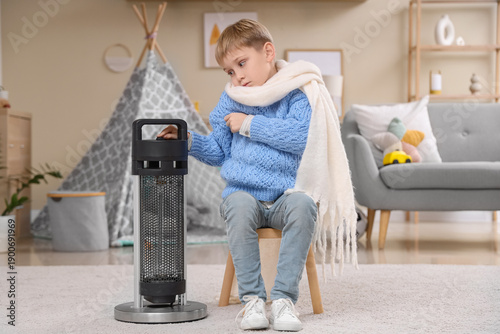 Frozen little boy sitting i...