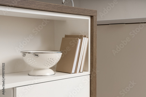 Colander with books on shel...