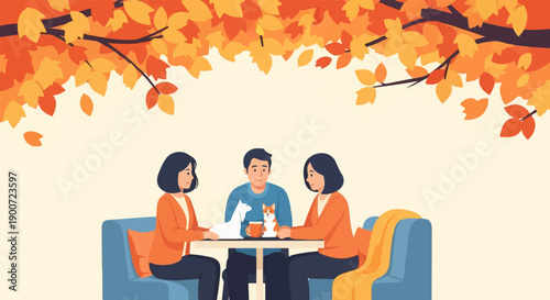 Three people and two dogs sit at a table under autumn leaves