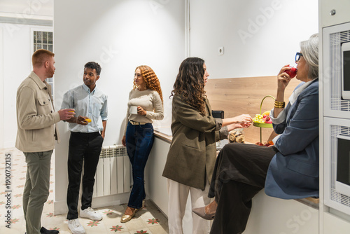 Obraz na plátně Coworkers interacting and eating snacks during a break in a modern shared office