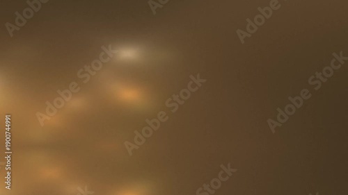 Blurry abstract image with warm tones and soft glowing light patterns