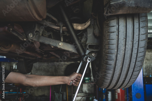 Auto mechanic replacing new rear shock absorbers ,shock absorber replacement in garage service shop.