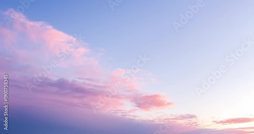 Timelapse of soft pastel clouds moving across a sunset sky. Pink and blue tones create a calm atmospheric background, ideal for nature, relaxation, and time passing concepts.