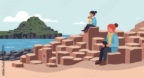 Two people and a dog relax on hexagonal rock formations by the sea with a green hill in background